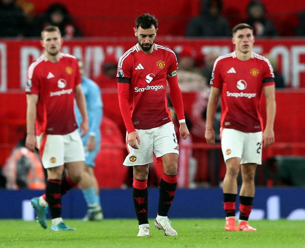 Dejected Manchester United players, including captain Bruno Fernandes (centre), after their home...