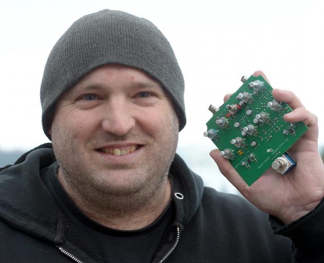Pepers’ Pedals owner and operator Tony Pepers shows off a circuit board for a prototype music...