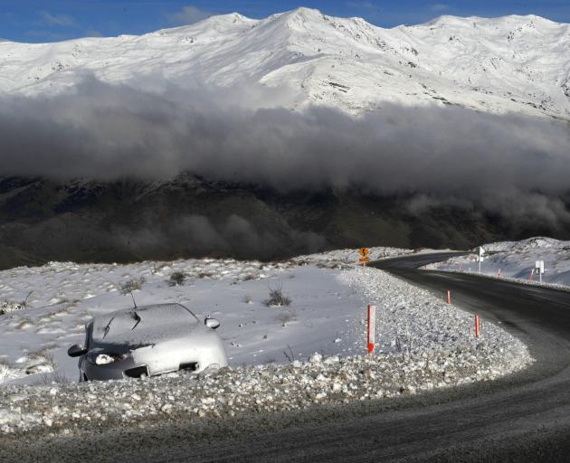 A snow-covered car sits abandoned off the Crown Range Road. FILE PHOTO: ODT