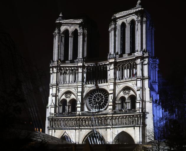 A light show is projected on the façade of Notre-Dame de Paris Cathedral during reopening...