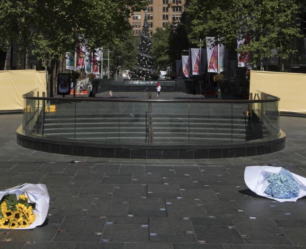 Two bunches of flowers lay on the ground at the site of a permanent memorial honouring the lives...