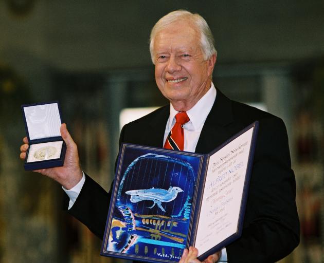 Former U.S. President Jimmy Carter holds his Nobel Peace Prize December 10, 2002 in Oslo, Norway....