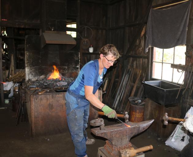 Nicol’s Blacksmith Trust chairwoman Jan Keeling demonstrates some blacksmithing techniques to...