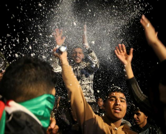 Palestinians react to news on a ceasefire deal with Israel, in Khan Younis in the southern Gaza...