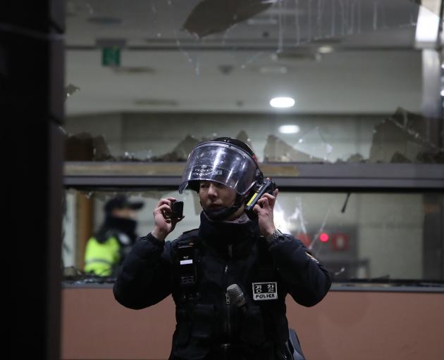 A South Korean police officer outside a court house after pro-Yoon protesters stormed the...