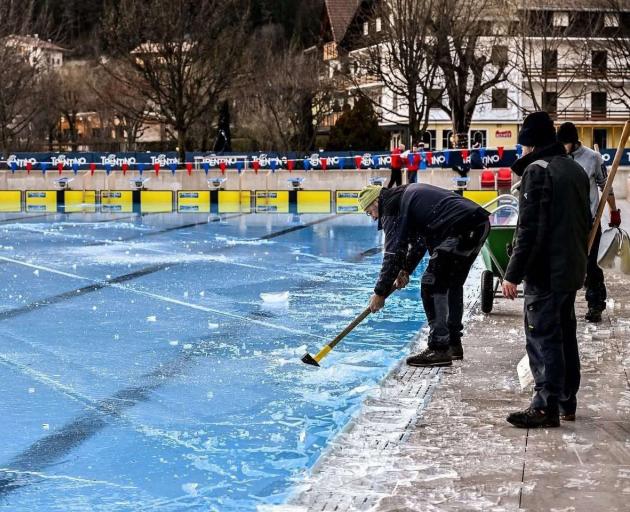 An official chips away at ice covering the pool at the International Ice Swimming Association...