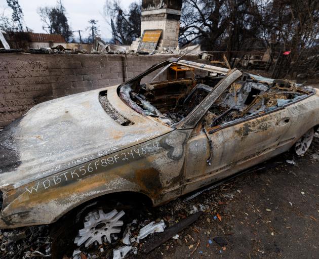 A burnt vehicle has its VIN Number written on its charred exterior as specialists (not pictured)...