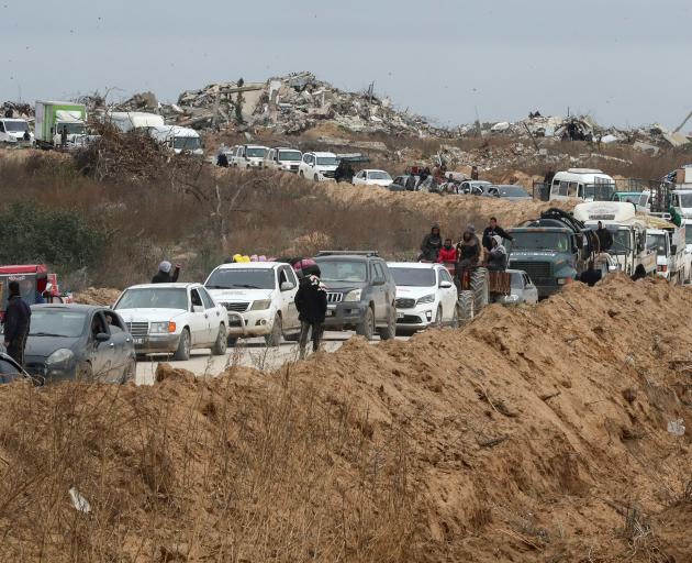 Palestinians wait to cross through a checkpoint run by US and Egyptian security contractors after...