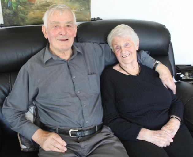 Arthur Warren, 89, cuddles on the couch with his wife, Joan, 85, as they recall how their love...