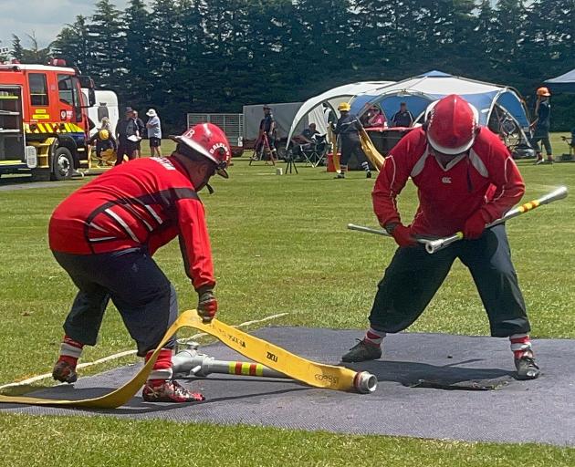 Balclutha firefighter athletes Taine Michie (left) and Nathan Davey rush to sink the standpipe to...