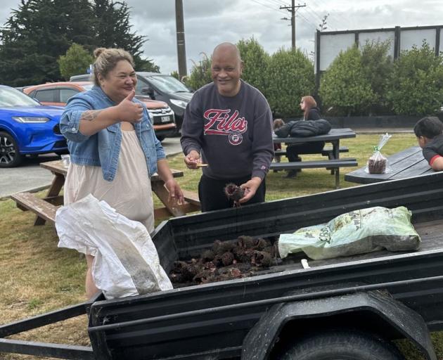 Rowie and Willie Tutapu Collins enjoy a feed of kina, fresh from the shore.