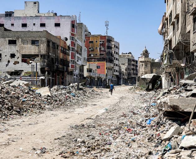 A man walks past rubble and damaged buildings in the Tuffah district east of Gaza City on July 8...