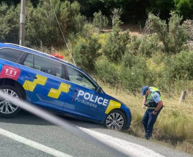 A police officer checks his patrol vehicle after going off road while trying to perform a U-turn....