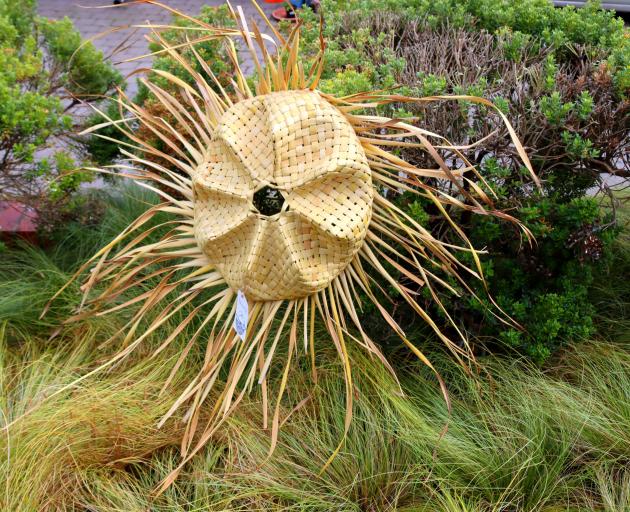 A sculptural form by Marc Taura combines natural and woven elements.