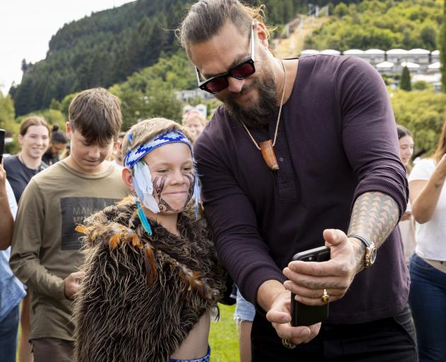 Hollywood star Jason Momoa takes a selfie with a local performer during the official Waitangi Day...