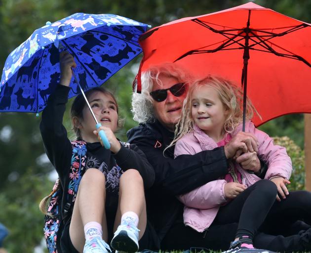 Snuggling under umbrellas are (from left) Ngaio, 10, Jill and Clover Thomson, 6, of Dunedin.