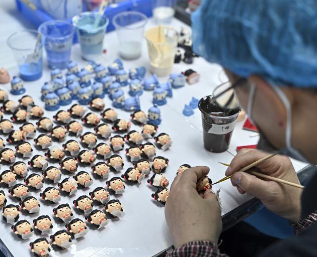 A worker makes toys depicting Nezha, the film’s main character, in Dongguan, Guangdong province....