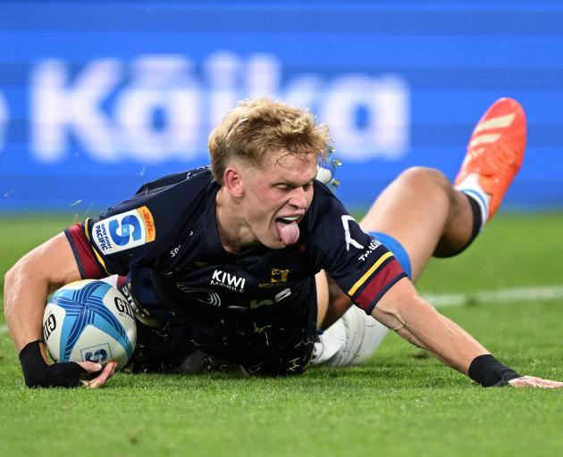 Finn Hurley celebrates after scoring a try during the Super Rugby Pacific match between the...