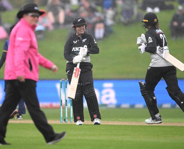 Georgia Plimmer and Suzie Bates of New Zealand depart the field for a rain delay. Photo: Getty...