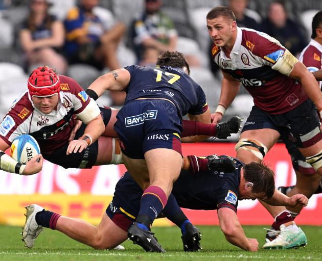 Harry Wilson of the Reds is tackled during today's Super Rugby Pacific match against the...