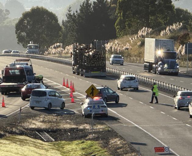 Police direct traffic at the Fairfield on-ramp following a crash this morning. Photo: Craig Baxter