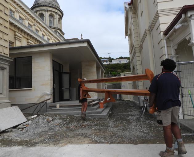 Replica pews built in Timaru from recycled heart rimu are carried into the new side entrance at...