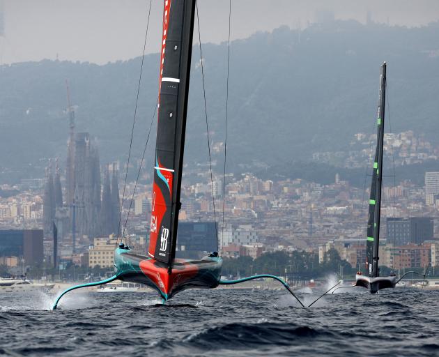 Team New Zealand aboard their AC75 monohull "Taihoro" (left) in Barcelona during the 2024 America...