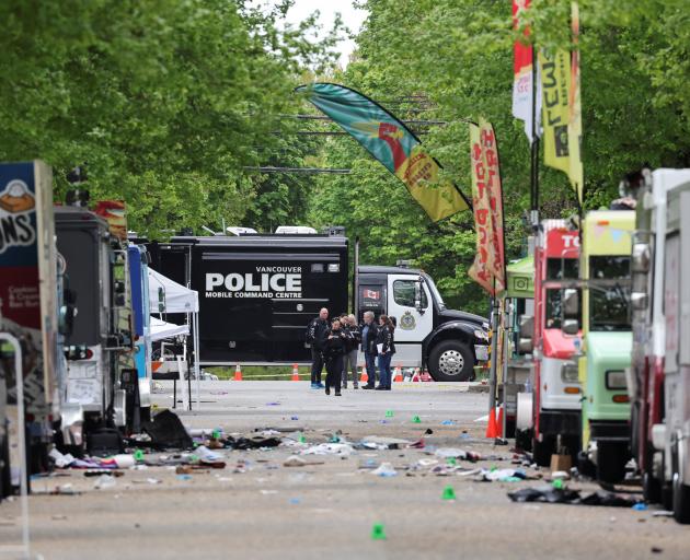 Police officers work at the scene, the morning after a vehicle was driven into a crowd at a...