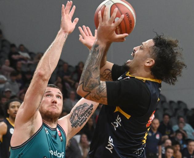 Otago Nuggets small forward Jose Perez gets a shot off despite the attention of Auckland forward...