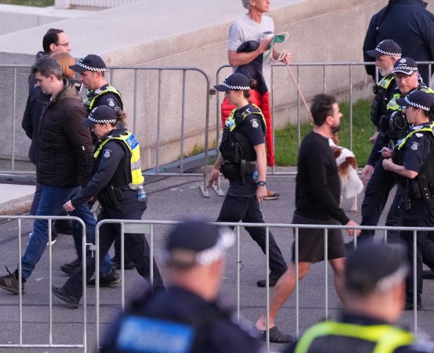Self-described neo-Nazi Jacob Hersant is escorted from the Anzac Day dawn service by police....
