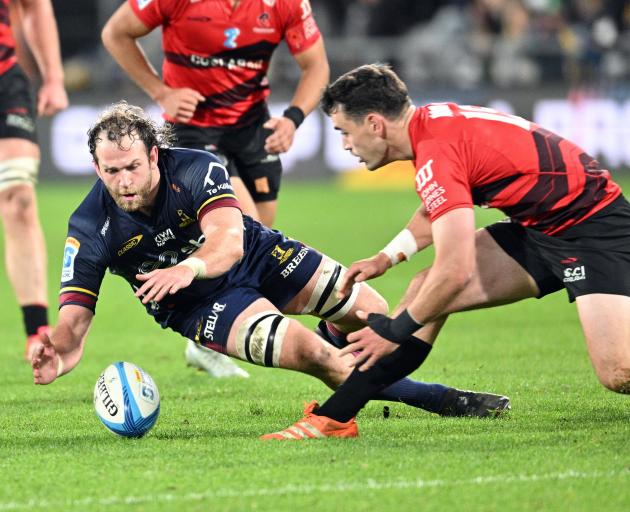 Highlanders forward Oliver Haig pounces on the ball in front of Crusaders fullback Will Jordan...
