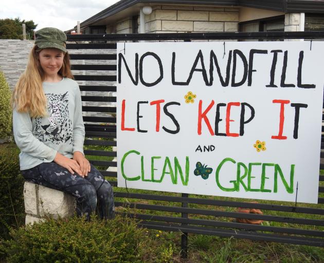 Olivia Smith beside a sign on a fence in Oxford opposing the proposal to establish an industrial...