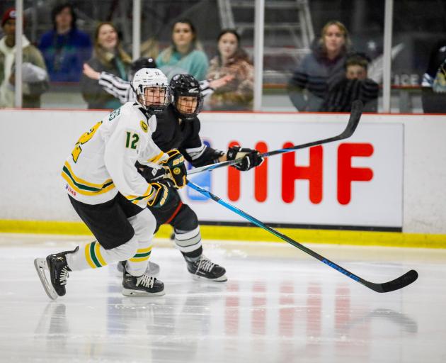 Australian ice hockey player Lily Roberts (left) and New Zealand’s Katya Blong chase the puck...