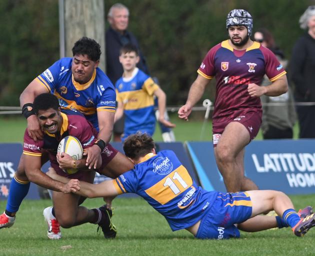 Alhambra-Union second five Manueli Rauqeuqe tries to break through Taieri defenders Kasimila...