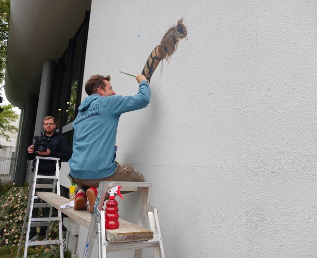 While artist Matt Willey paints a scout bee, The Good of the Hive film director of photography...