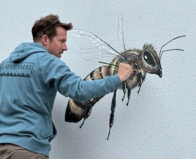 A scout bee takes shape on the wall of the ANZ Bank building in Timaru under artist Matt Willey’s...