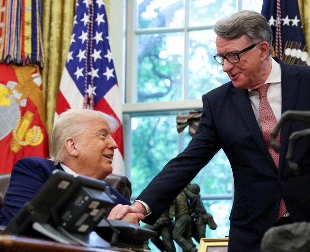 US President Donald Trump shakes hands with Britain's ambassador Peter Mandelson after announcing...