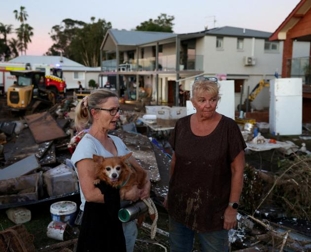Sue Allport stands with a woman outside her home which was hit by flooding, in Glenthorne, NSW....