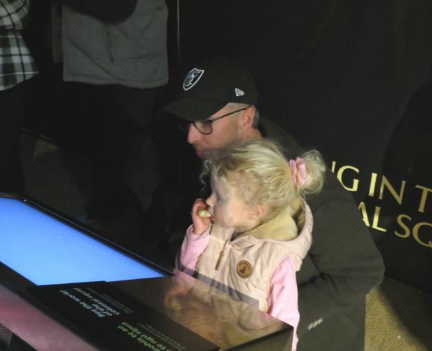 Michael Kelly and daughter 3-year-old Sia read about the colossal squid at the twilight zone...
