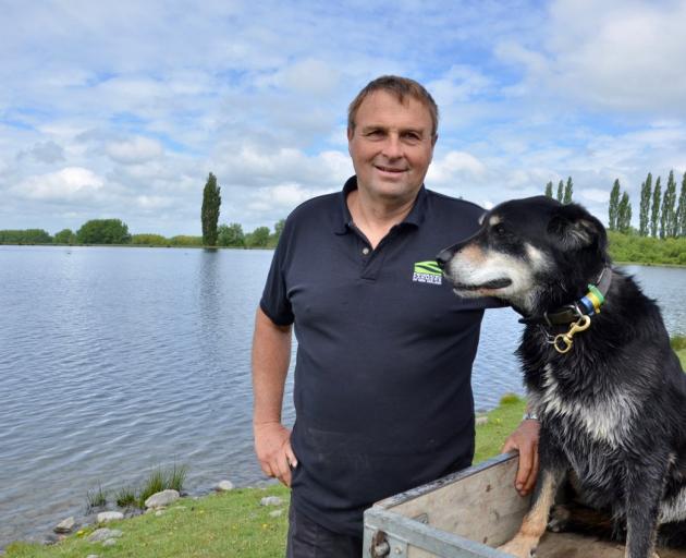 The late Chris Allen, with working dog Ace beside the irrigation lake he created on his farm near...