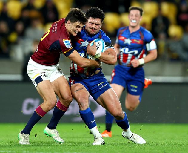 Highlanders first five Taine Robinson tackles Hurricanes loosie Du’Plessis Kirifi during their...