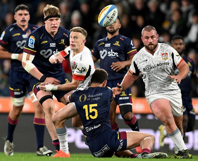 Chiefs first five-eighth Damian McKenzie passes before being taken down in a tackle by Highlander...