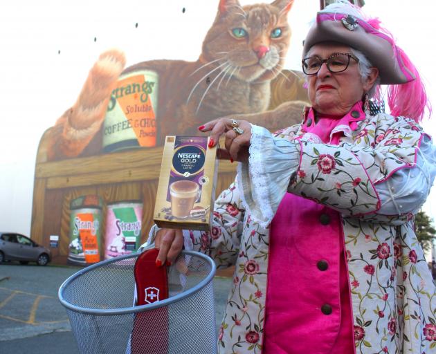 Invercargill town crier Lynley McKerrow in front of a Strang’s Coffee mural shows what she thinks...