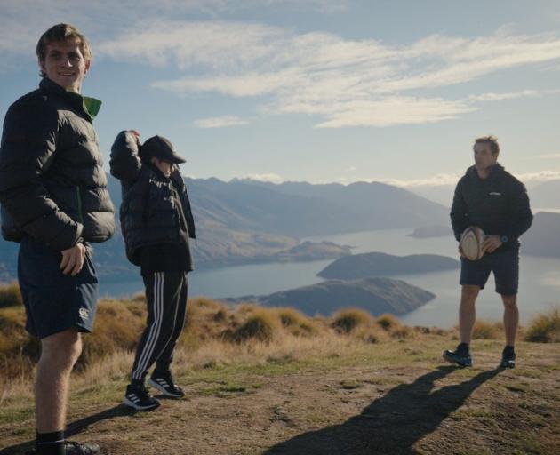 McCaw (right) throws the rugby ball around with Mr Davison (left) and Eli at the top of...