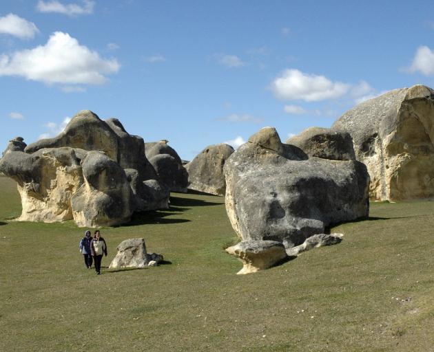 Visitors wander through some of the limestone left by the early formation of New Zealand, at the...