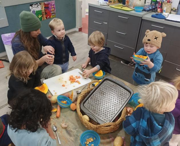 Teacher Jessie Reynolds helps Arrowtown Preschool tamariki prepare vege soup for Monday’s...