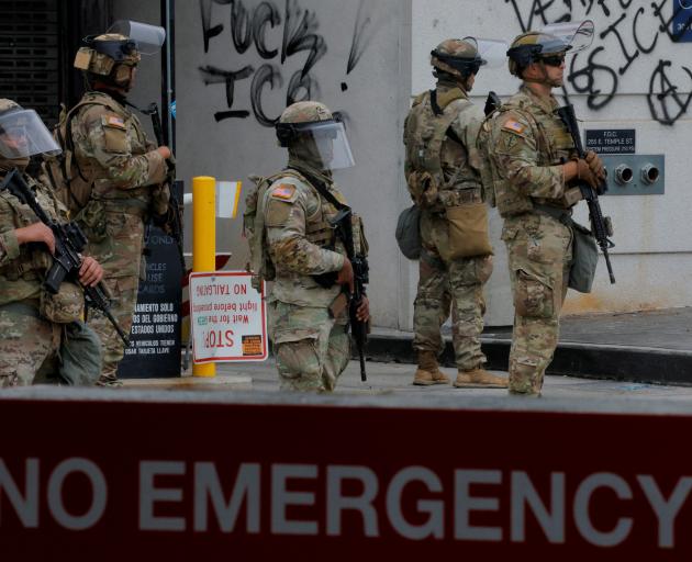 National Guard troops stand outside the Edward R. Roybal federal building, in Los Angeles. Photo:...