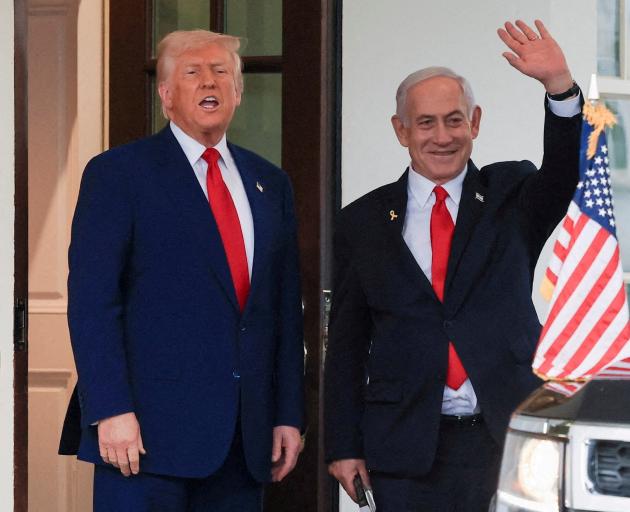 President Donald Trump speaks as Israeli Prime Minister Benjamin Netanyahu waves following a...