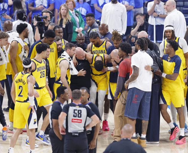 Indiana Pacers star Tyrese Haliburton is helped from the court after his first half injury. Photo...