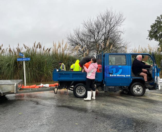 Residents and contractors build a sandbag wall on the corner of Hathaway and Gouland streets to...